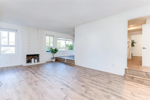 wooden floor fireplace and windows in an empty room