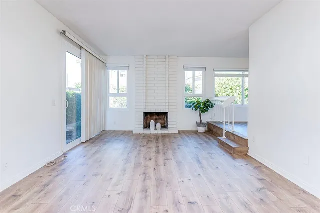 an empty room with wooden floor and fireplace