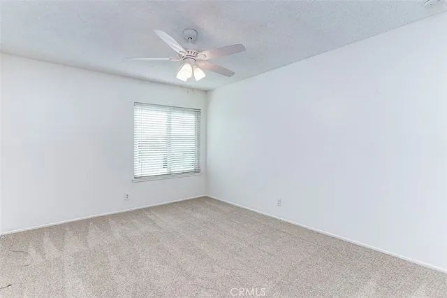 a view of a big room with a ceiling fan and carpet