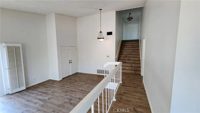 a view of a hallway with wooden floor and staircase