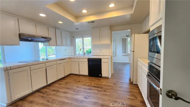a large kitchen with stainless steel appliances sink a microwave and cabinets