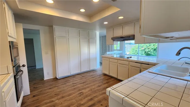 a kitchen with stainless steel appliances kitchen island granite countertop a refrigerator and a sink