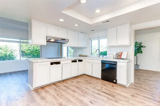 a kitchen with granite countertop a stove top oven sink and cabinets