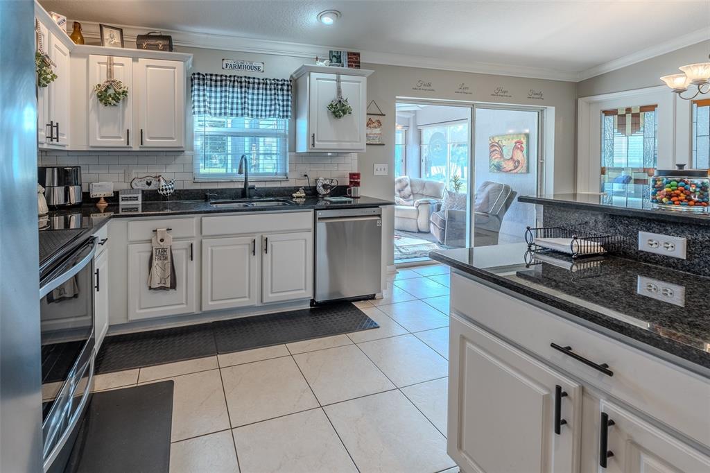 15143 Southwest 14th Avenue Road Ocala, FL 34473 - Photo 13 of 53 a kitchen with stainless steel appliances granite countertop a sink stove and cabinets