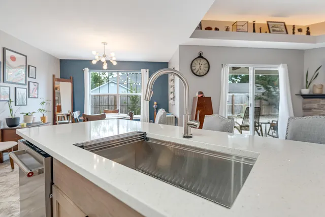 a kitchen with kitchen island a dining table chairs cabinets and stainless steel appliances