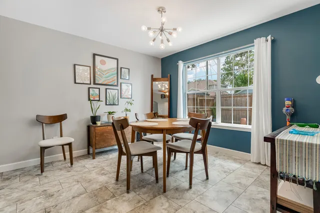 a bedroom with a bed lamp on desk and a window