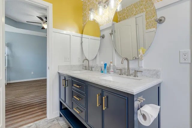 a bedroom with a bed next to a window with a chandelier