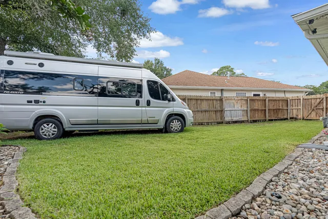 a view of a yard with wooden fence