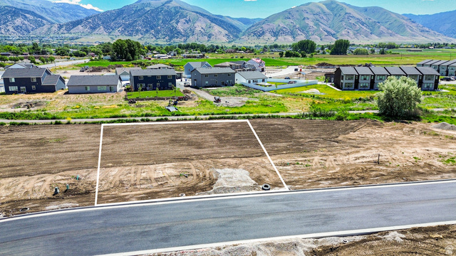 3230 South 1125th West, Unit 21 Logan, UT 84321 - Photo 2 of 20 Cleared building lot featuring defined boundaries, direct paved road access, visible utility stub-outs, and panoramic mountain scenery