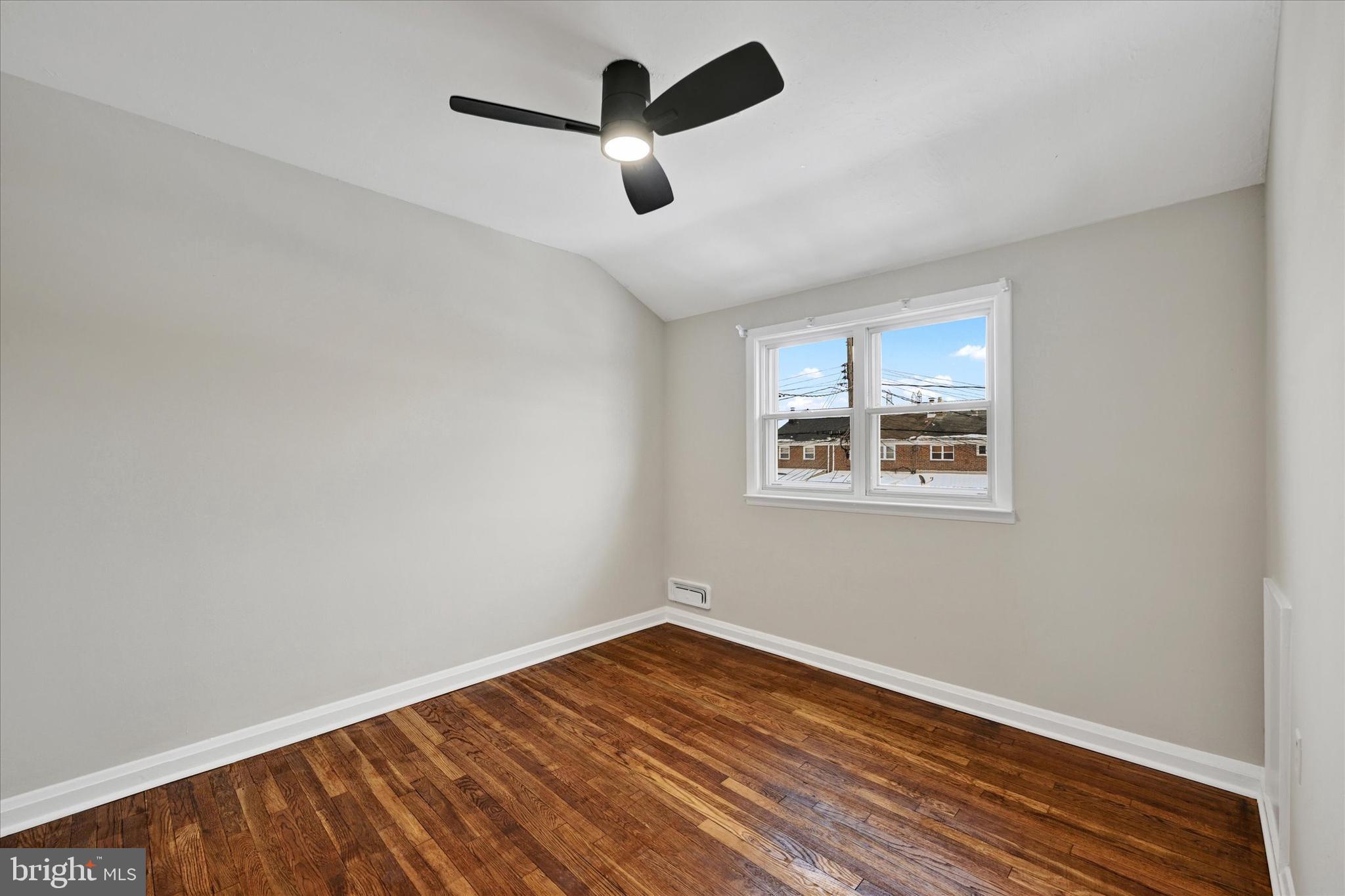 1945 Ormand Road Baltimore, MD 21222 - Photo 14 of 28 an empty room with wooden floor ceiling fan and windows
