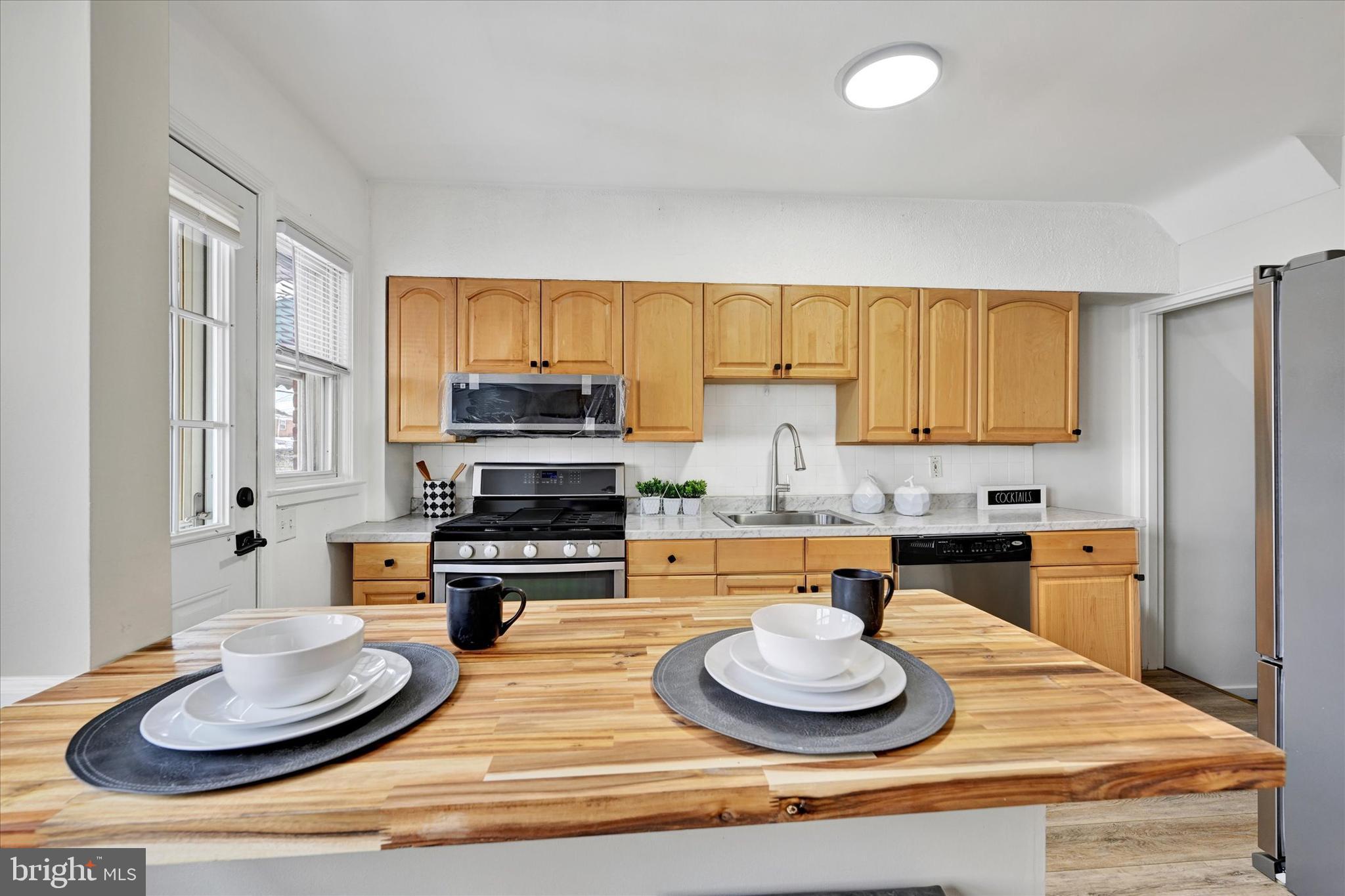 1945 Ormand Road Baltimore, MD 21222 - Photo 8 of 28 a kitchen with a stove a sink and a wooden cabinets