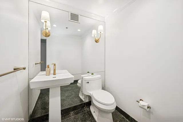 a bathroom with a sink a toilet and mirror