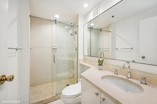 a bathroom with a sink toilet double vanity and shower