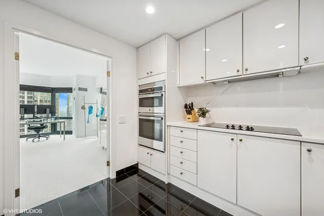 a kitchen with granite countertop white cabinets and white appliances