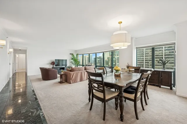 a dining room with furniture a chandelier and window