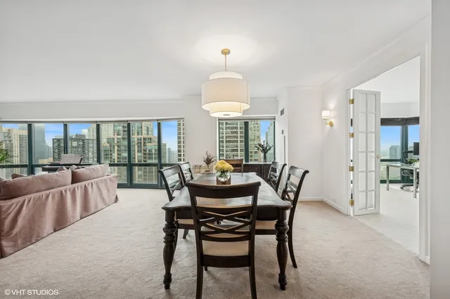 a dining room with furniture wooden floor and a chandelier