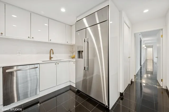 a kitchen with white cabinets and refrigerator