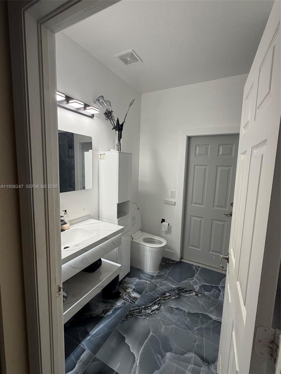 685 Southeast 37th Place Homestead, FL 33033 - Photo 11 of 11 a bathroom with a toilet sink and a mirror