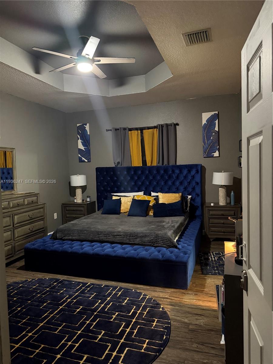 685 Southeast 37th Place Homestead, FL 33033 - Photo 7 of 11 a bedroom with a bed and wooden floor