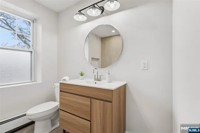 a bathroom with a toilet a sink and mirror