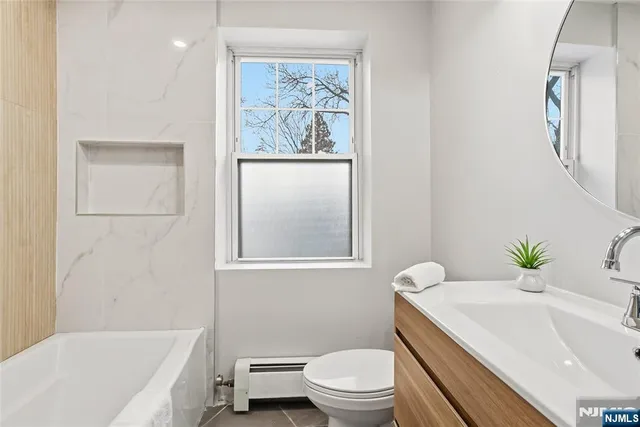 a bath room with a toilet a sink and a bath tub