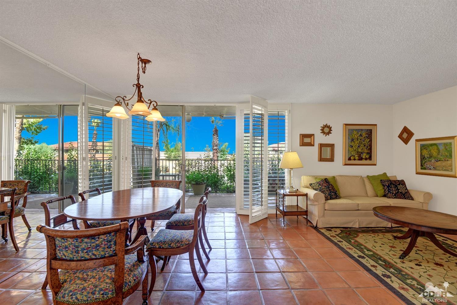 42278 Dunes View Road, Unit 27 Rancho Mirage, CA 92270 - Photo 1 of 20 a living room with furniture a dining table and a chandelier