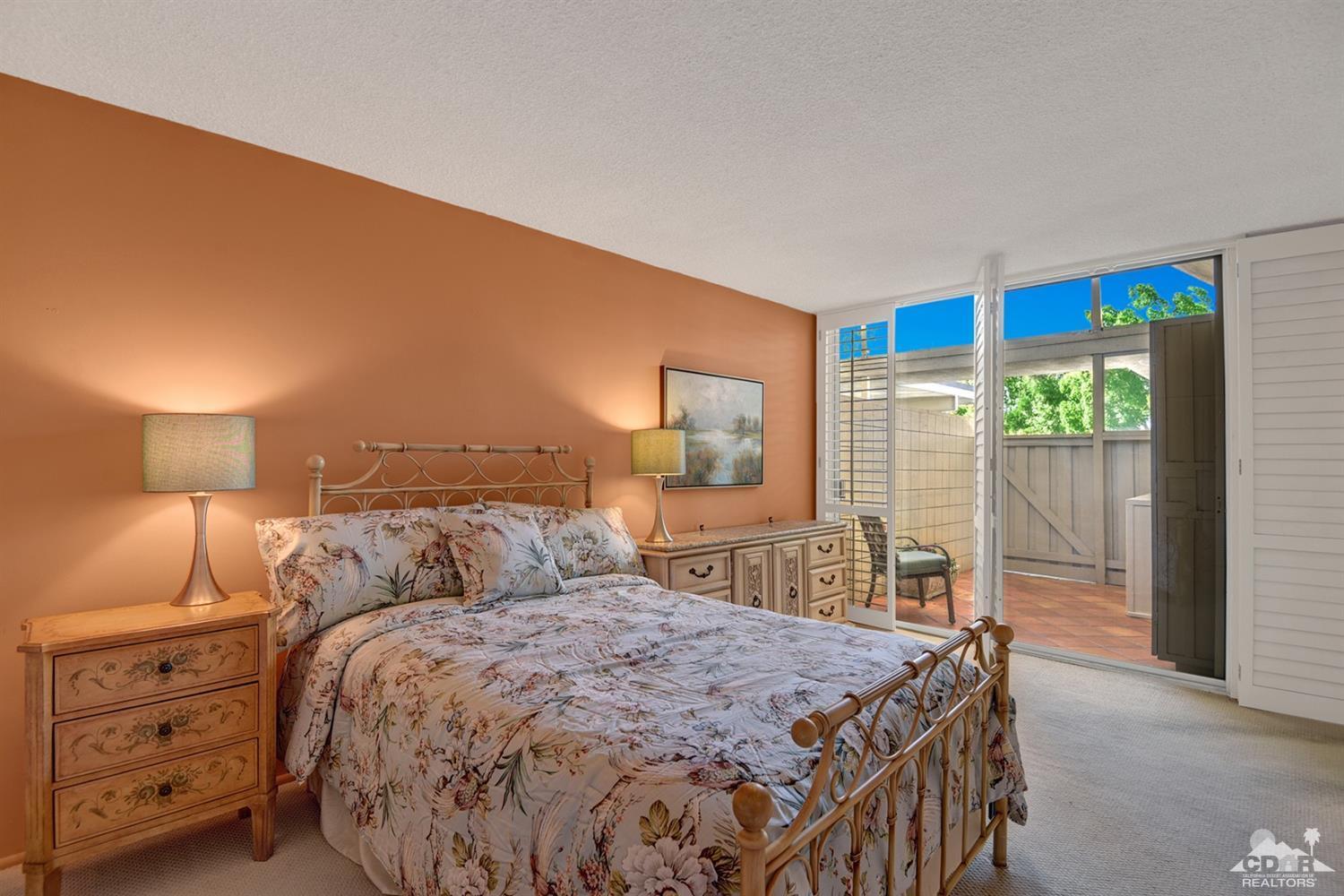 42278 Dunes View Road, Unit 27 Rancho Mirage, CA 92270 - Photo 13 of 20 a bedroom with a bed and a lamp with window