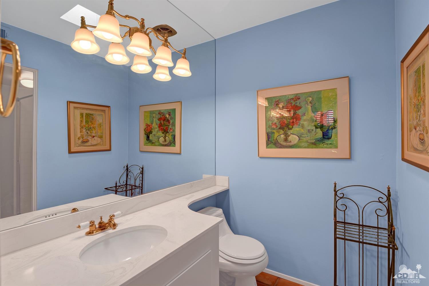 42278 Dunes View Road, Unit 27 Rancho Mirage, CA 92270 - Photo 14 of 20 a bathroom with a toilet a sink a mirror and vanity