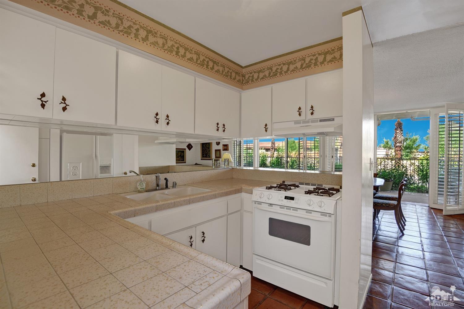 42278 Dunes View Road, Unit 27 Rancho Mirage, CA 92270 - Photo 9 of 20 a kitchen with white cabinets and white appliances