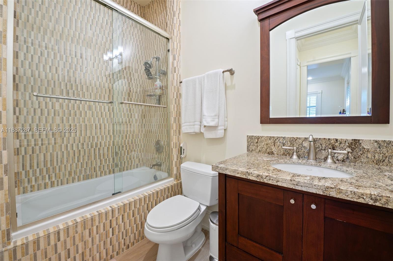 9601 Southwest 60th Court Pinecrest, FL 33156 - Photo 36 of 61 a bathroom with a granite countertop sink toilet and shower