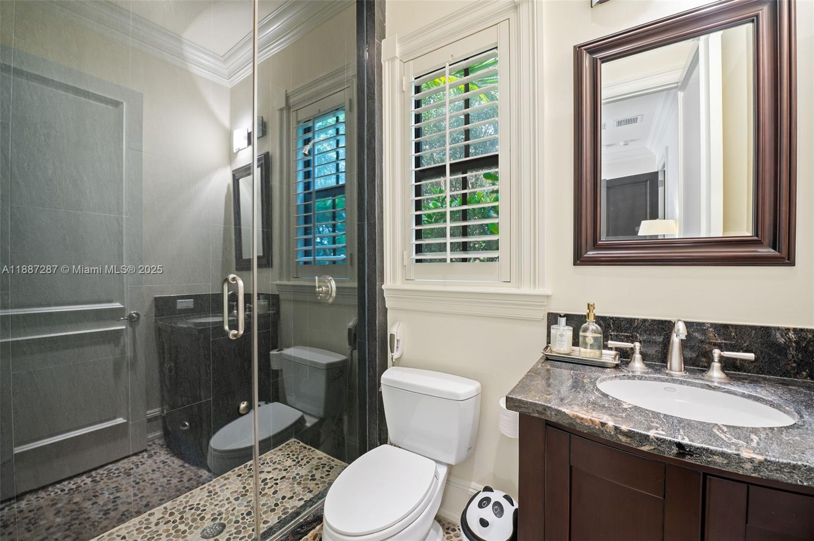 9601 Southwest 60th Court Pinecrest, FL 33156 - Photo 40 of 61 a bathroom with a granite countertop toilet sink and mirror