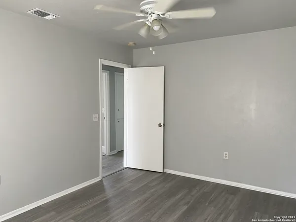 a view of an empty room with wooden floor