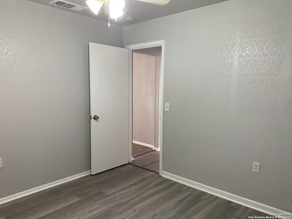 a view of an empty room with wooden floor