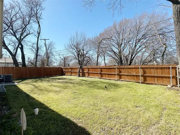 a view of backyard with wooden fence