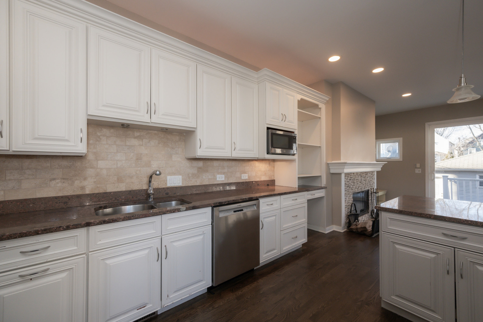 1701 West Byron Street Chicago, IL 60613 - Photo 12 of 57 a kitchen with granite countertop white cabinets and white appliances