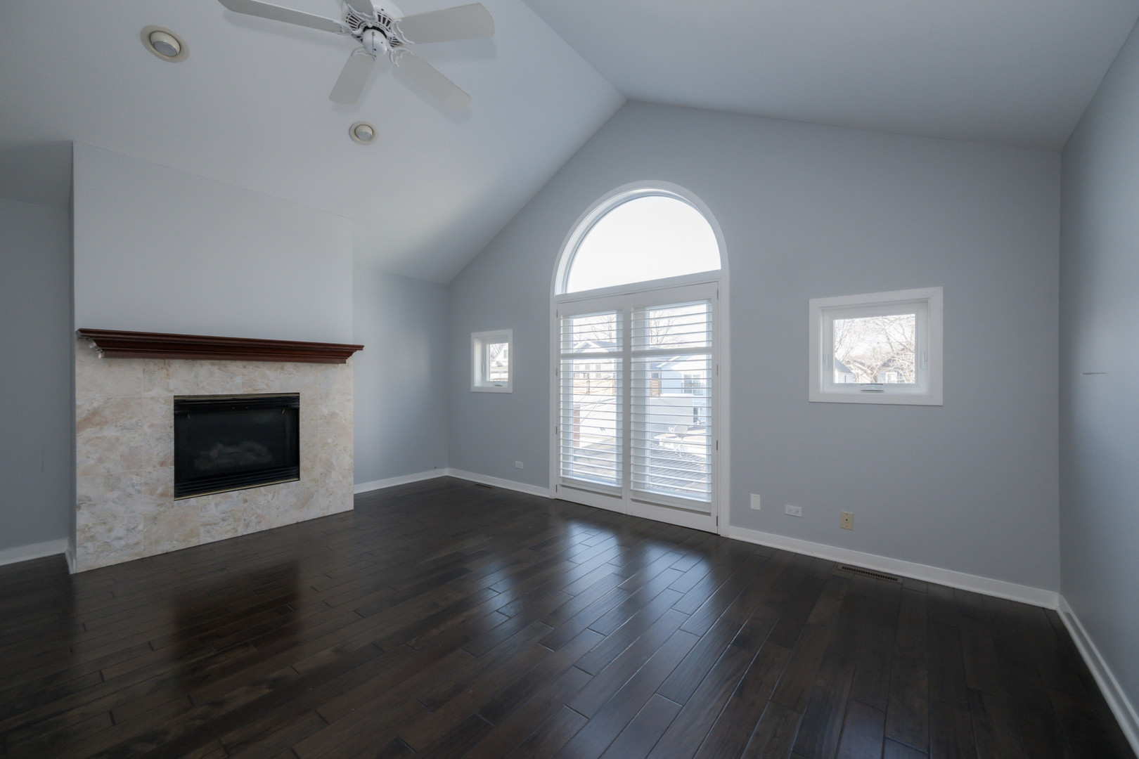 1701 West Byron Street Chicago, IL 60613 - Photo 25 of 57 an empty room with wooden floor a fireplace and windows