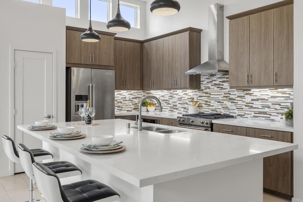2026 Tango Loop, Unit 3 Chula Vista, CA 91915 - Photo 3 of 34 a kitchen with stainless steel appliances kitchen island granite countertop a sink and cabinets