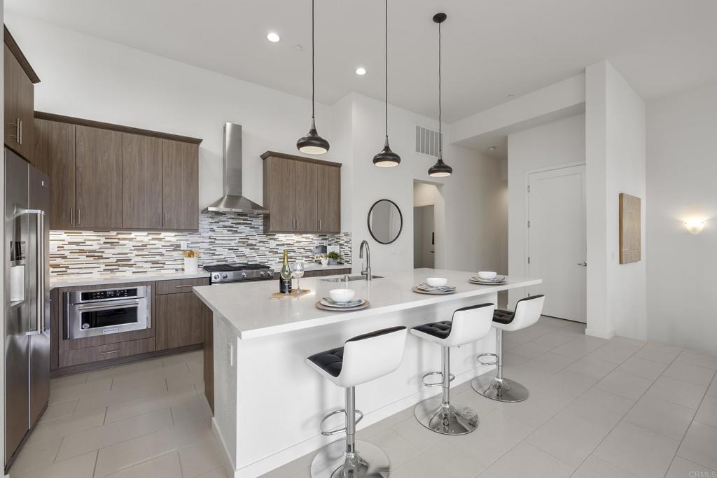 2026 Tango Loop, Unit 3 Chula Vista, CA 91915 - Photo 9 of 34 a kitchen with stainless steel appliances kitchen island granite countertop a sink and cabinets