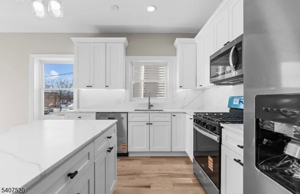 a kitchen with cabinets stainless steel appliances and a sink