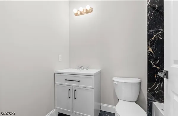 a white toilet sitting next to a bathroom sink