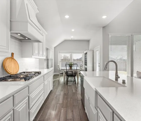 a kitchen with stove a sink and cabinets