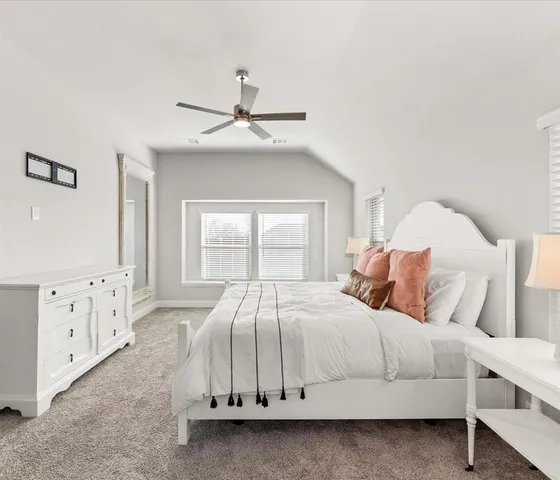 a bedroom with a white bed and white walls