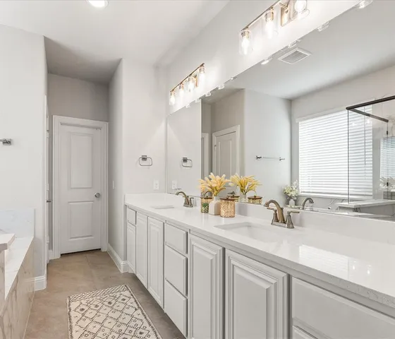 a bathroom with a double vanity sink and a mirror