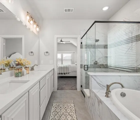a bathroom with a double vanity sink a mirror and a bathtub