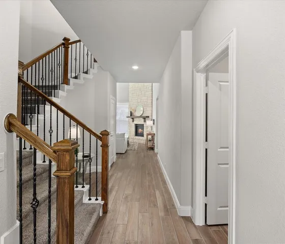 a view of a hallway with wooden floor and entryway