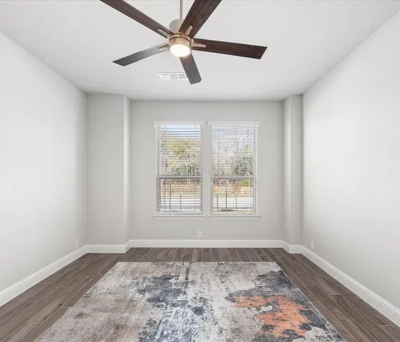 a view of a big room with wooden floor and windows