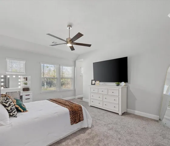 a bedroom with a bed a window and a television