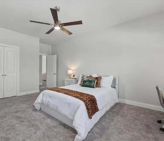 a bedroom with a bed and a ceiling fan
