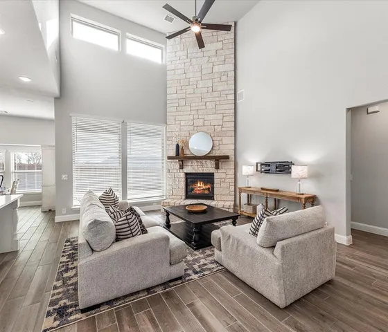 a living room with furniture a fireplace and wooden floor