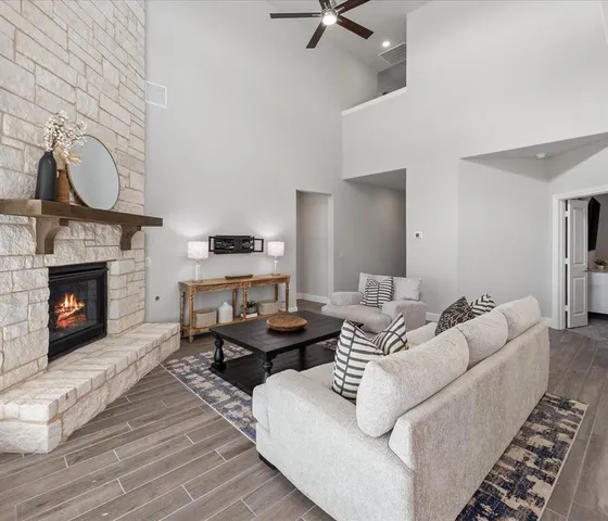 a living room with furniture a fireplace a rug and a wooden floor